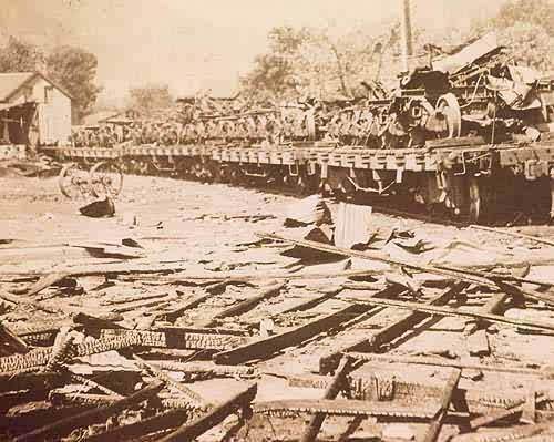 Trucks and Twisted Iron Loaded on Flat Cars